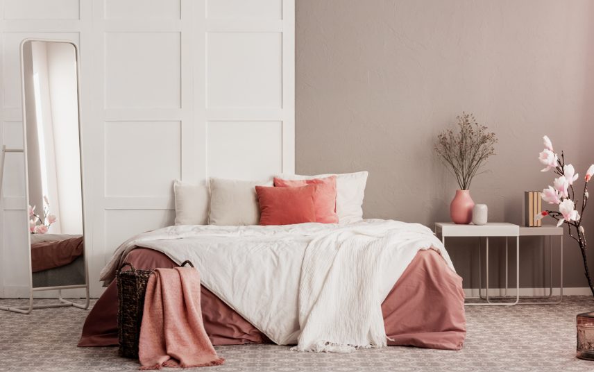 Moderne Schlafzimmergestaltung mit altrosa Wandfarbe  gemütliches Bett & Beistelltischen – Beispiel mit Schlafzimmer Deko Vasen & Standspiegel