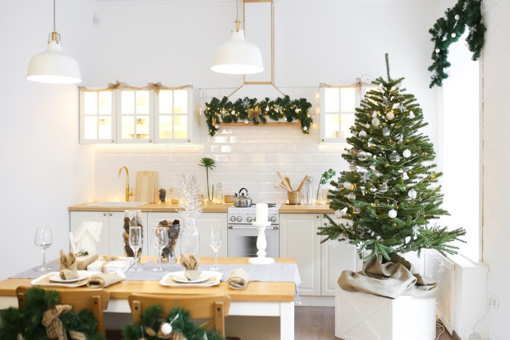 Kleiner Weihnachtsbaum mit dezentem Schmuck in Silber und weiß in der Küche