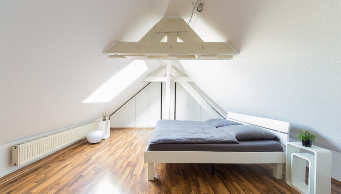 Gestaltungsbeispiel für ein modernes Dachzimmer mit modernen Möbeln in weiß - Moderne Nachttische in weiß mit Pflanze als Dekoration - Deckenspots als Beleuchtung
