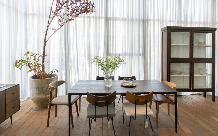 Einrichtungsidee für ein Esszimmer im Haus – Beispiel mit dekorierten Holztisch & Stühlen – Vitrine & Lowboard – große Pflanze im Pflanzgefäß