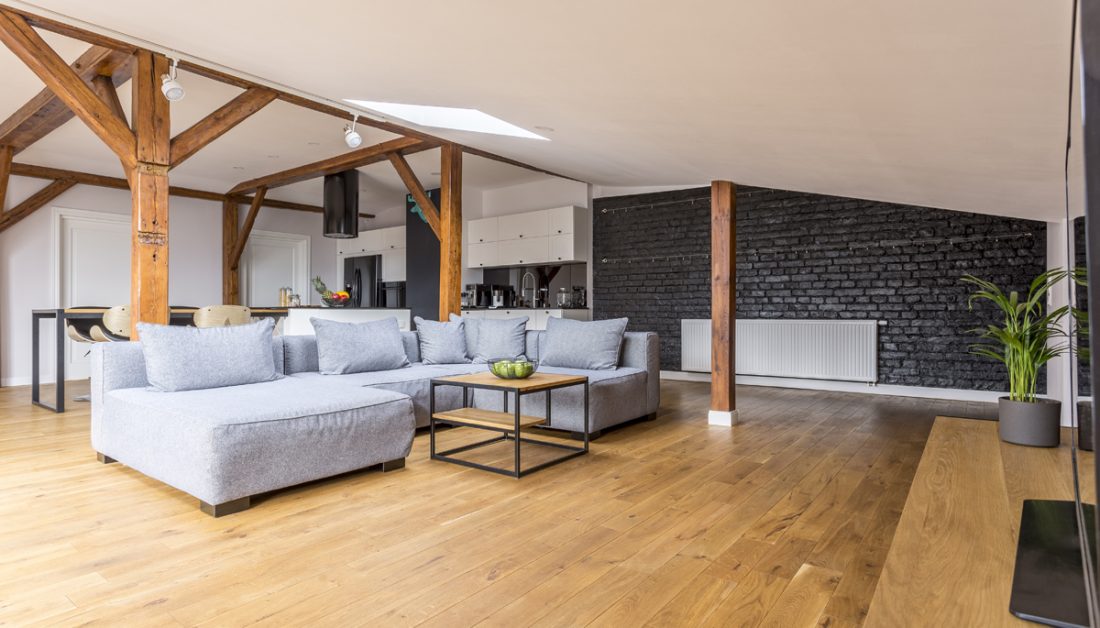 Wohnidee - Beispiel für ein geräumiges Wohnzimmer unter dem Dach im klassischen Stil mit grauem Sofa  Couchtisch & schwarzer Ziegelwand - Deckenleiste mit Lampen