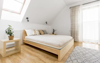 Idee für ein Gästezimmer im Dachgeschoss mit Holzmöbeln – Beispiel mit Holzbett & Nachttische a...