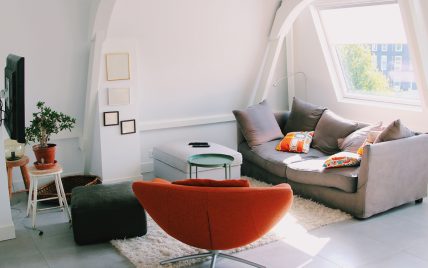Wohnidee – Jugendzimmer unter dem Dach mit grauem Sofa  Drehsessel & eckigen Sitzkissen auf dem Te...