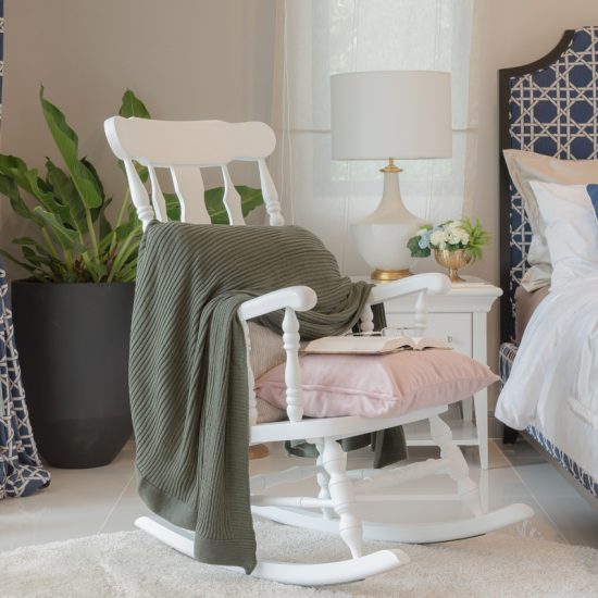 Landhaus Schlafzimmer Deko Idee mit weißen Schaukelstuhl - Beispiel mit dekorierten Nachttisch  Nachttischlampe & gemütliches Polsterbett - Großes Pflanzgefäß mit Zimmerpflanze