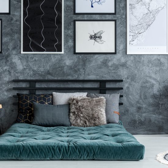 Schlafzimmer Beispiel mit modernen Futonbett - Wanddekoration mit Bildern in Bilderrahmen - Beistelltisch mit Glockenwecker  Vasen mit Dekoblatt in gold