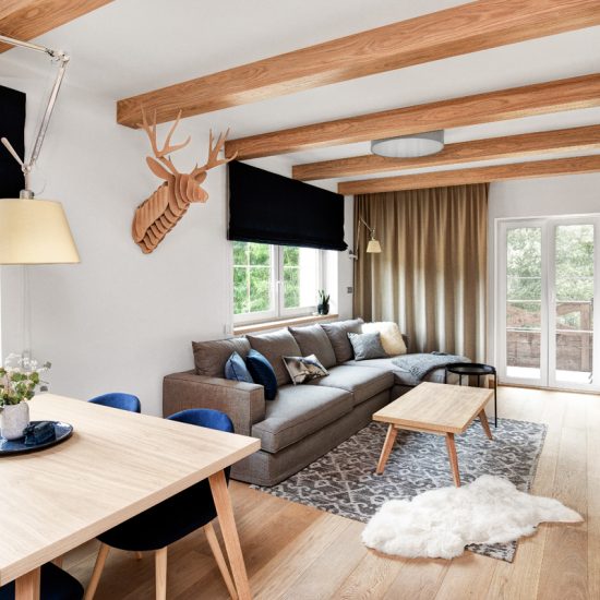 Landhaus Appartement Wohnung im modernen Landhausstil eingerichtet - Idee mit grauen Stoffsofa & Beistelltisch auf einem Teppich - Essbereich mit Esstisch & Schalenstühlen