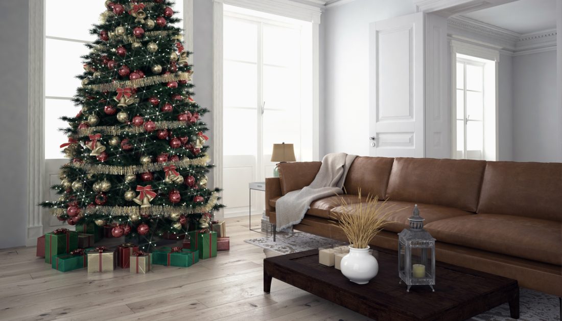 Gestaltungsidee für ein Wohnzimmer im Altbau mit Weihnachtsdekoration - Beispiel mit braunen Ledersofa & Holzbeistelltisch - Großer Weihnachtsbaum mit Weihnachtsbaumschmuck