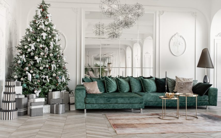 Beispiel für ein großes Wohnzimmer mit Weihnachtdeko – Grünes Ecksofa kombiniert mit Metalltischen – Moderne Tischlampe – Geschmückter Weihnachtbaum