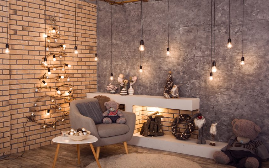 Wohnidee – Modernes Kaminzimmer mit Weihnachtsdekoration – Skandinavischer Sessel & Beistelltisch – viele Weihnachtsfiguren & Vasen