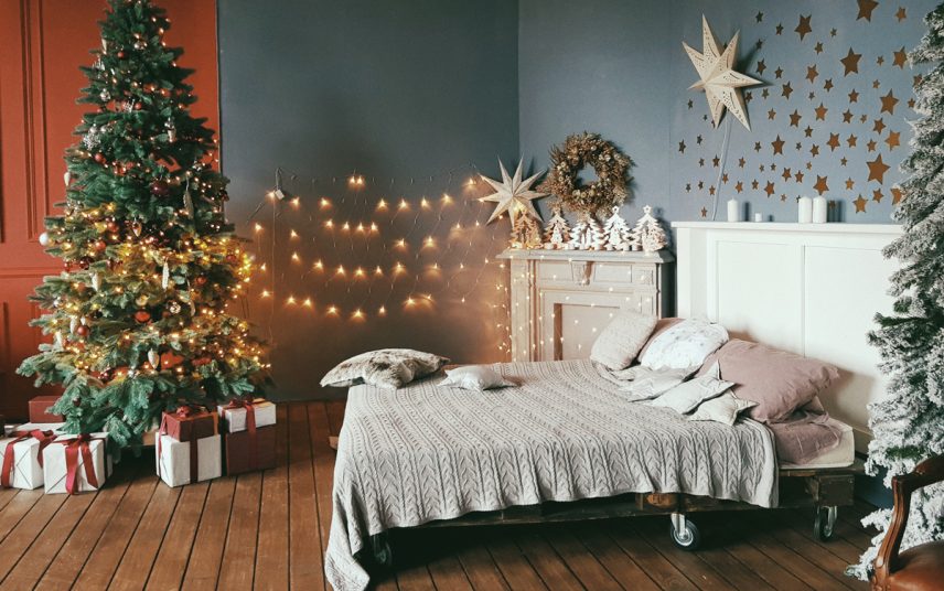 Schlafzimmer Idee mit Weihnachtsdeko & Adventsdeko – Geschmückter Weihnachtsbaum mit Lichterkette – Kissen & Decken auf dem Futonbett – Wandgestaltung mit Sternen