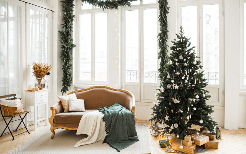 Weihnachtlich geschmücktes Wohnzimmer im barocken Stil – Idee mit dekorierten Weihnachtsbaum & Weihnachtsgirlande – Antiksofa  Beistellschrank & Stuhl