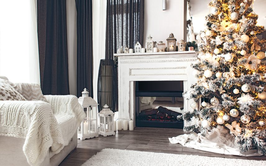 Weihnachtsdeko Idee für das Kaminzimmer oder Wohnzimmer – Weißer Sessel mit Decke – Geschmückter Weihnachtsbaum & Kamin mit viel Weihnachtsdeko – Laternen & Weihnachtsfiguren