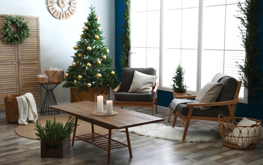 Wohnzimmer im Retrostil mit Weihnachtsdeko – Gemütliche Retrosessel kombiniert mit dekorierten Holztisch – Geschmückter Weihnachtsbaum  Kerzen & Fellteppich
