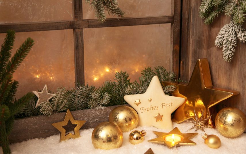 Idee für die Fensterbank mit Weihnachtsdeko – Beispiel mit goldenen Weihnachtskugeln & Weihnachtssternen – Dekoschnee & Tannenzweige auf dem Fensterbrett – Teelicht in Sternform
