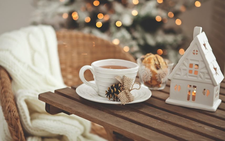 Beispiel für Winterdeko auf einem Holztisch – rustikaler Rattanstuhl mit weißer Decke – Weihnachtsdeko Idee
