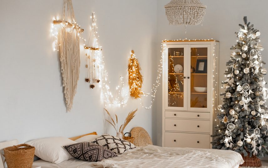 Stilvoll dekoriertes Schlafzimmer im Landhausstil mit Weihnachtsdeko – Wohnidee mit Lichterkette & Wandteppich Makramee als Deko – Bett mit Kissen & Decken