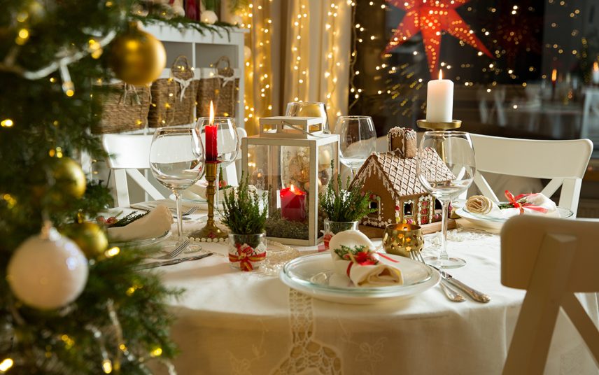 Gestaltungsidee für den runden Esstisch zu Weihnachten – Beispiel mit weißer Laterne  Kerzenständer  Teelichter & Lebkuchenhaus – weiße Tischdecke