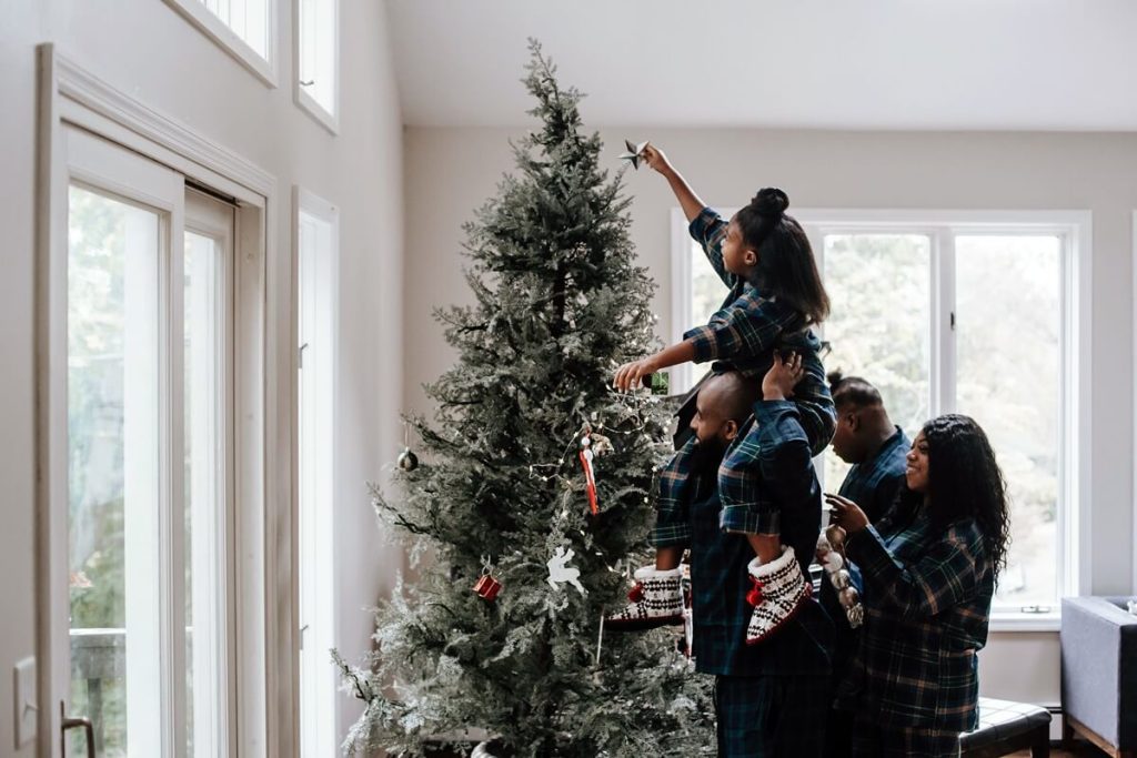 Familie schmückt gemeinsam ihren Weihnachtsbaum