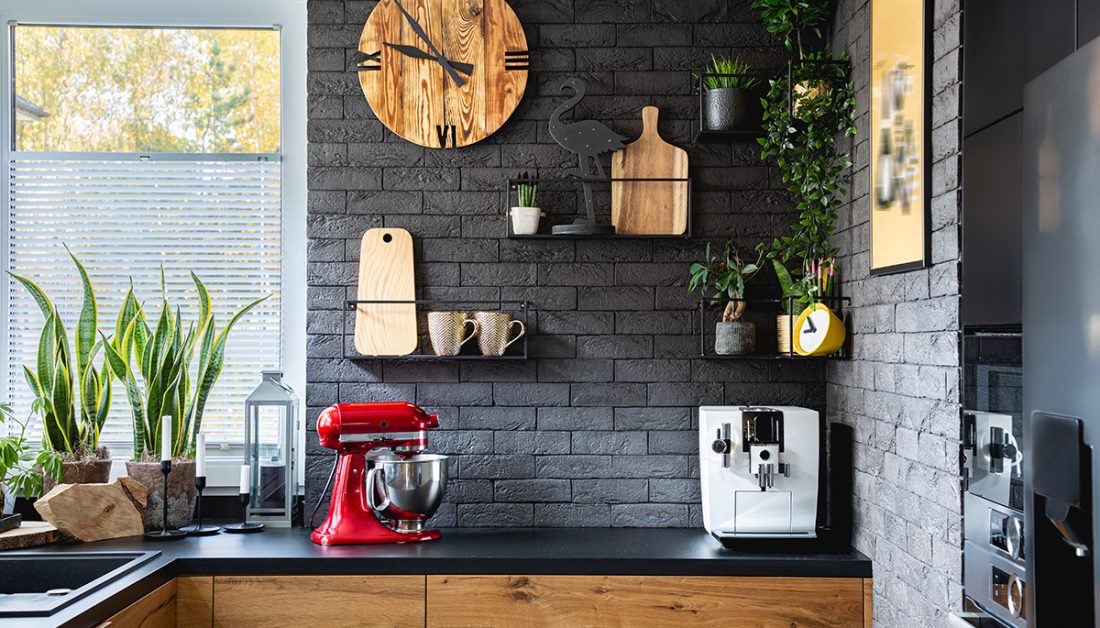 Wohnidee - Rustikale Küche mit dunkler Steinwand & Wandgestaltung - schwarze Wandregale aus Metall - Küchenuhr aus Holz & Küchendekoration