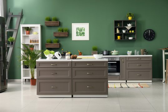 Küchen Idee - Moderne Küche mit grüner Wandgestaltung - graue-braune Küchenzeile mit Kochinsel - Wanduhr  Wandregal & Bild als Küchen-Wanddekoration