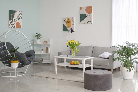 Dekoriertes Wohnzimmer im skandinavischen Stil mit Frühlingsdeko – Graues Sofa & weißer Couchtis...