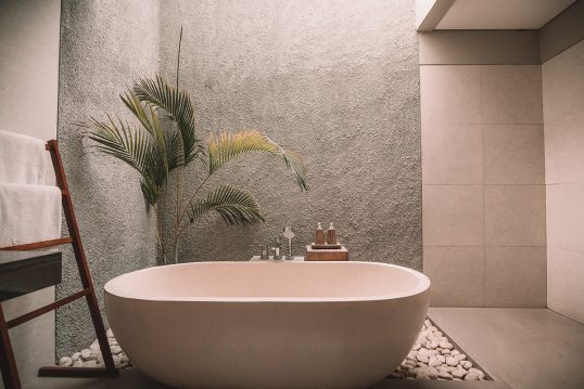 Feng Shui Badezimmer Idee – Heller Raum mit Betonwand – Freistehende Badewanne und Beistelltisch...