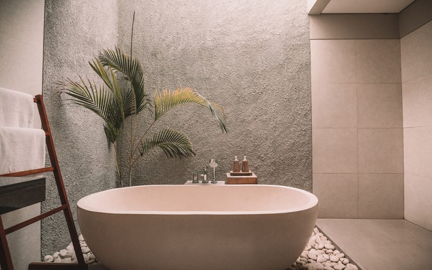 Feng Shui Badezimmer Idee – Heller Raum mit Betonwand – Freistehende Badewanne und Beistelltisch