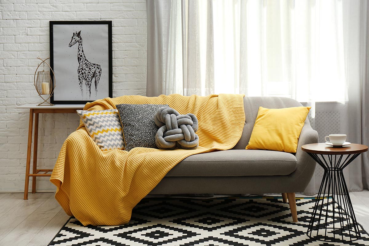 Kissen und Decken sorgen für mehr Wohnlichkeit und Komfort im Raum.