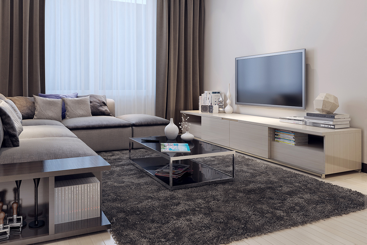 Moderne Wohnzimmereinrichtung mit hellem Lowboard für den Fernseher und grauem Sofa.