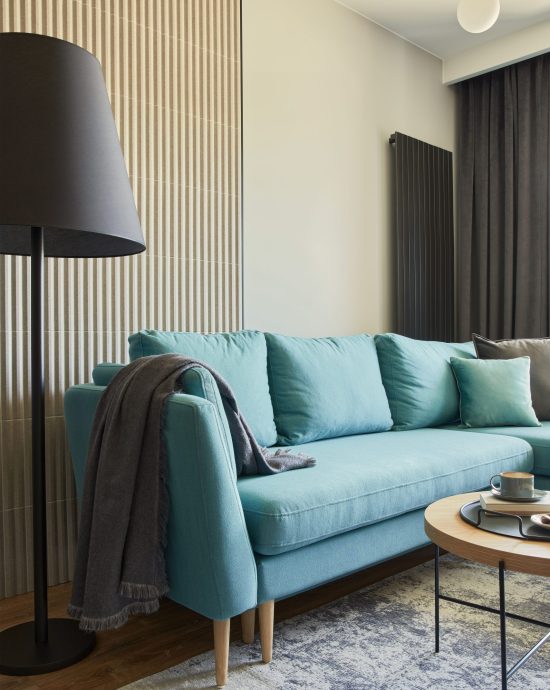Modernes Wohnzimmer mit blauem Sofa & Lampe