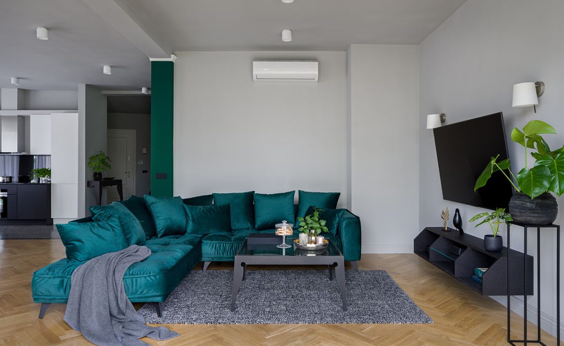 Einfache Wohnzimmereinrichtung im modernen Stil mit blauem Sofa & grauem Teppich
