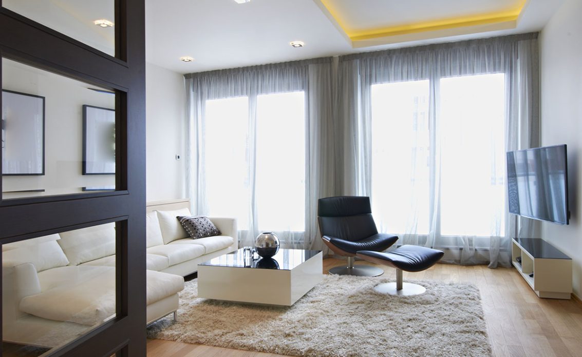 Modern eingerichtetes Wohnzimmer mit weißem Ledersofa  Sessel & Couchtisch