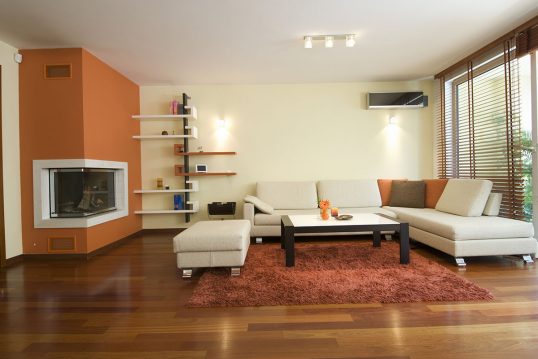Wohnzimmergestaltung mit Akzenten in orange & Ecksofa