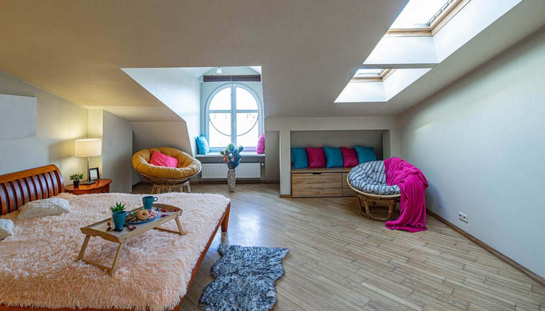 Großes Gästezimmer im Dach mit Doppelbett und Korbstühlen  bunte Akzente mit farbigen Kissen